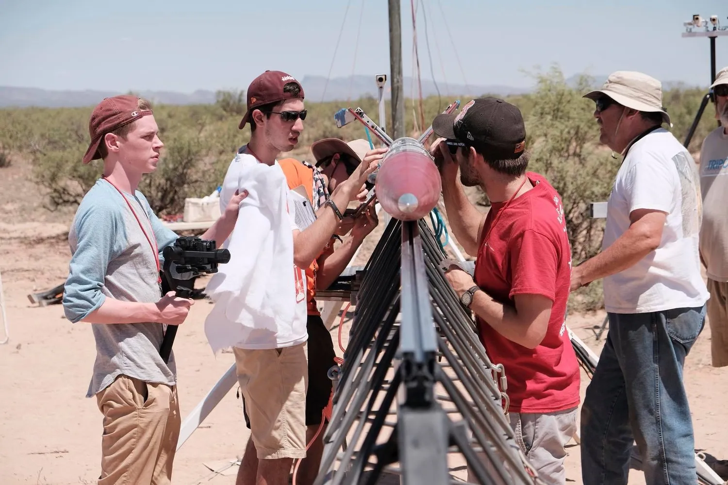 Several Members of the Rocketry at Virginia Tech team standing in front of the teams rocket at the Spaceport America Cup loading onto the launch rail